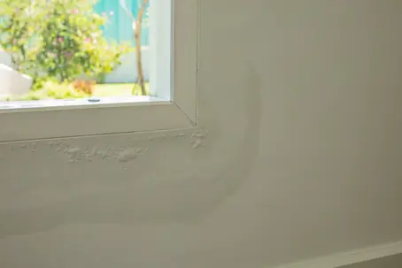 bubbling drywall and water staining around a window frame